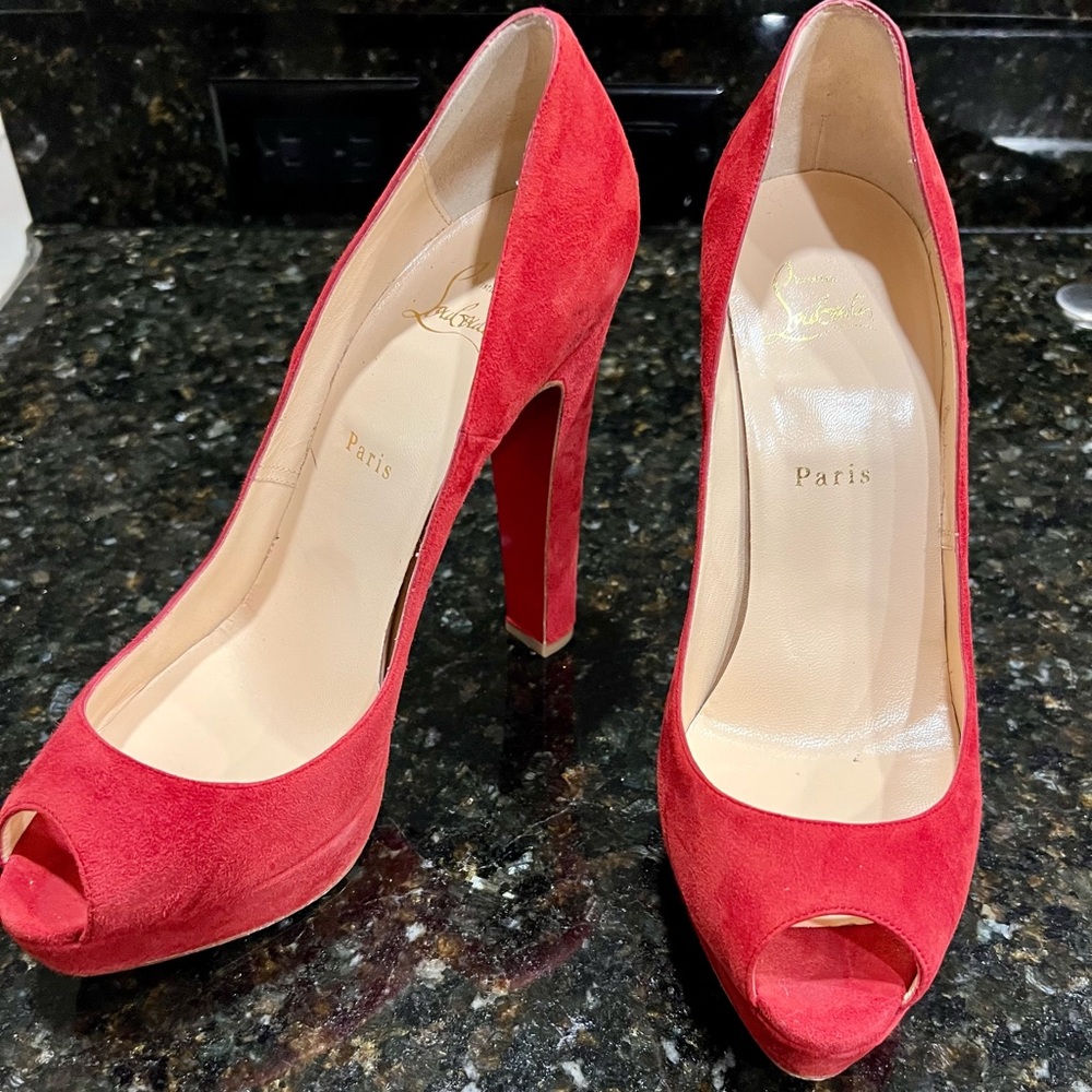 Christian Louboutin red suede peep toe pumps.